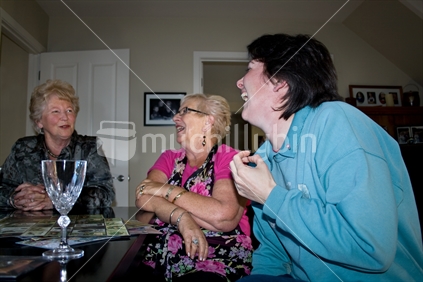 Three New Zealand women of mixed ages enjoying relaxed conversation.