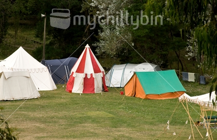 Variety of tents at a quiet camping ground, with towels drying on the fence; Waipara, North Canterbury.
