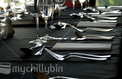 Elegant black and silver table setting in early evening lighting.