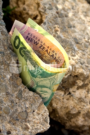 Money disappearing through cracks in concrete rubble (either saved or waster).