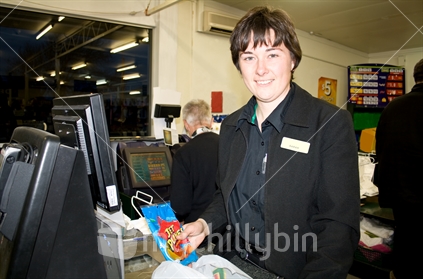 Woman supermarket worker at a checkout
