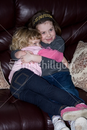 Two young sisters hug each other