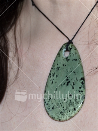 Kokopu (greenstone) pendant on bare skin  (focus on the lower right of the stone)