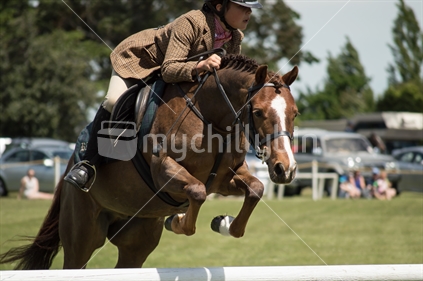 Pony and rider clearing a jump