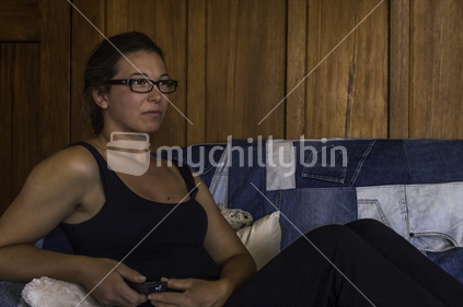 Woman relaxing on a couch, remote in hand