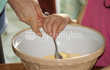 Mother helping daughter to bake