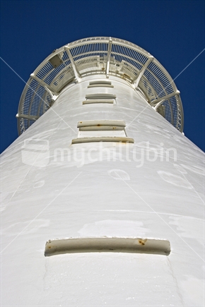 Looking up at the Castlepoint lighthouse against a vivid blue sky