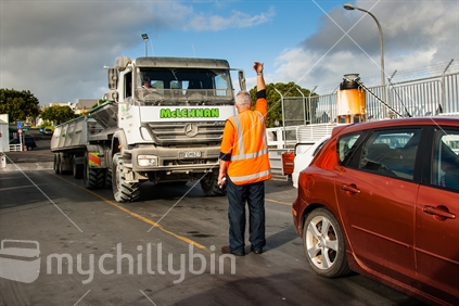 A crew member uses hand signals to direct a truck onto the ferry at Rawene.