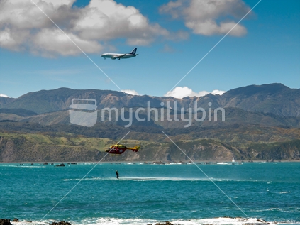 A simulated victim is plucked from the sea during a helicopter rescue exercise in Wellington; as Air New Zealand flys overhead.