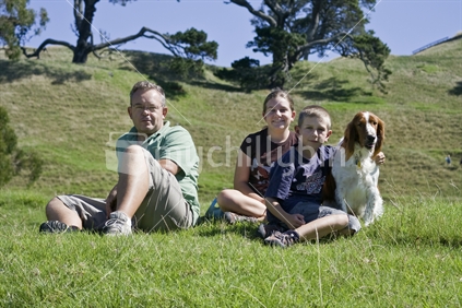 Father and children sitting on grass