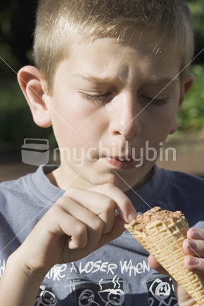Eleven year old caucasian male eating an ice cream