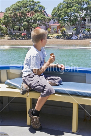 Boy eating an ice cream on a boat in Russel, Bay of Islands