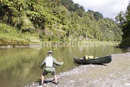 Teenage child throwing rocks into the Whanganui River, New Zealand