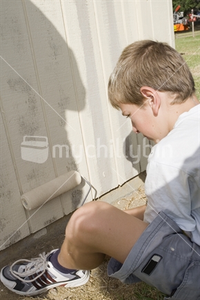 Teenage boy painting a wall