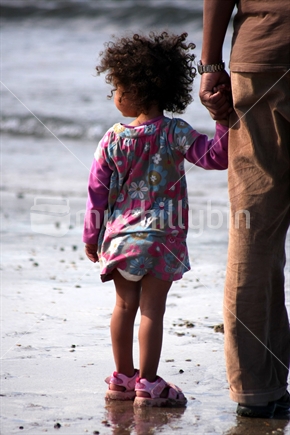 Little girl with her father on the beach 