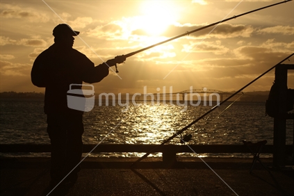 Fishing off Devonport wharf at sunset, New Zealand
