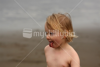 Blonde girl enjoying the outdoors, west coast beach, New Zealand