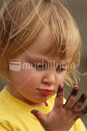 Young girl with sandy fingers, New Zealand