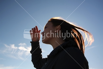 Silhouette of a woman against blue sky, New Zealand
