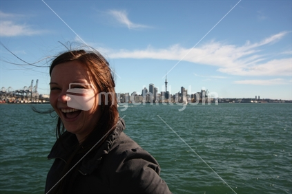 Woman in front of Auckland skyline (from Devonport ferry), New Zealand

