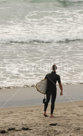Surfer at Whangamata Beach, Coromandel, New Zealand
