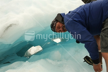 Helihike inspection of crevase, at Franz Josef Glacier, South Island, New Zealand.
