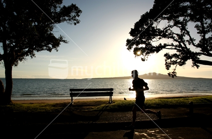 a jogger at Narrow Neck beach with Rangitoto Island in the background, North Shore, Auckland
