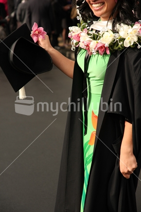 Female graduate in Auckland with colourful flower necklace.