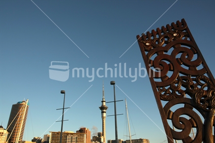 Auckland Skytower, seen from Viaduct Basin, with Maori wooden carving 
