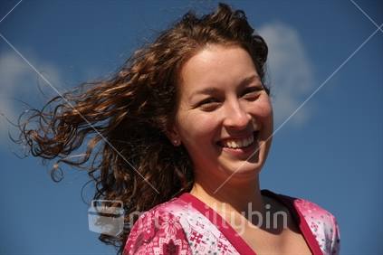 Woman enjoying a blue sky day in New Zealand. 