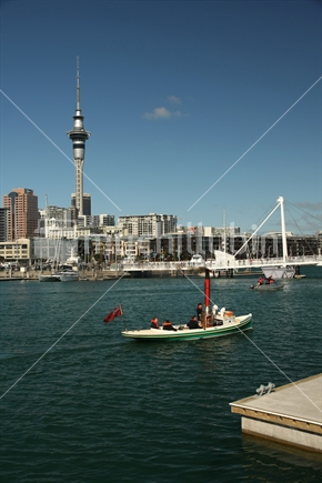 Auckland Skytower, seen from Wynyard Quarter with vintage steam powered vessel in foreground.
