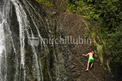 Rock climbing at Kitekite waterfalls near Piha, Waitakeres, New Zealand