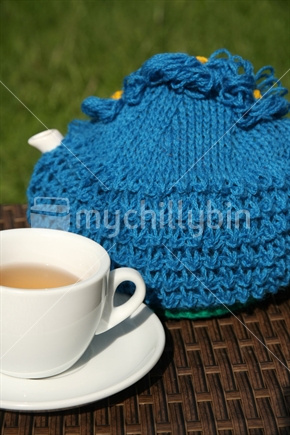 Teapot with a knitted tea cosy.
