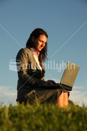 Professional woman at a laptop, in the New Zealand outdoors