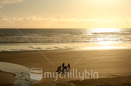 Two mums with prams at Muriwai beach in the late afternoon sun, Auckland, New Zealand.