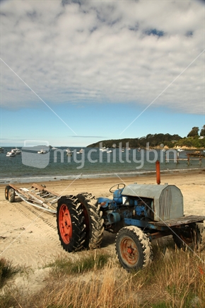 Tractor in Oban with Halfmoon Bay in the background, Stewart Island, New Zealand