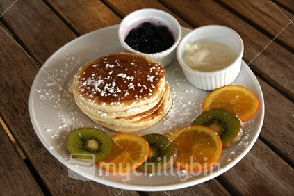 Pancakes with kiwifruit and orange slices