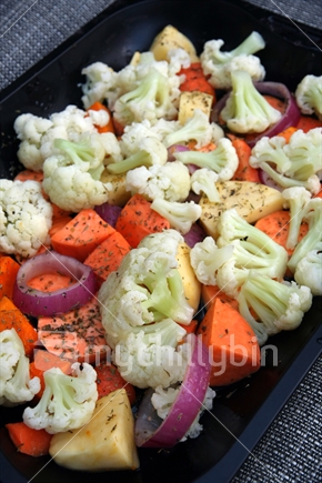 Vegetable roast with cauliflower, kumara, onions and carrots ready to cook.