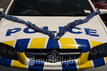 A police car decorated for a christmas procession.