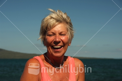 Woman having a laugh, Rangitoto behind.