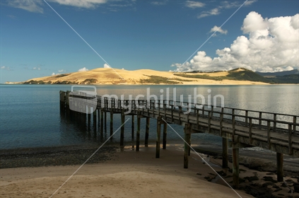 old pier in Omapere with sand dunes in the dinstance, Northland