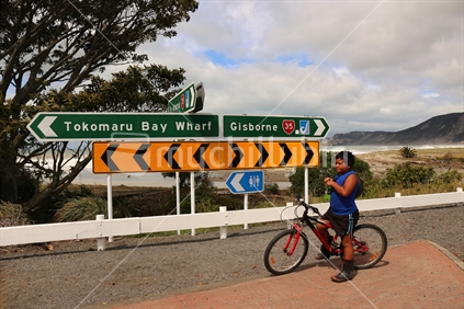 maori boy in front of road signs, East Cape