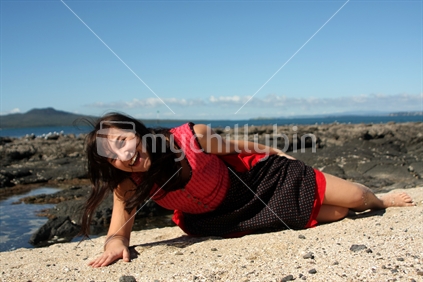 young woman lying on the beach in a Bavarian dress