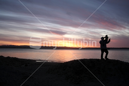 Father and child at sunset over the Waitakeres from Point Chevalier 