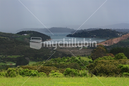Rain approaching Waiheke Island from the west.  Quarry on the RHS of image. 