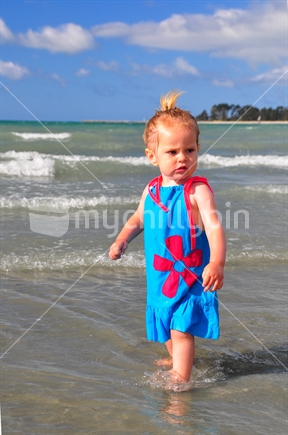 Girl playing in water; all at sea.