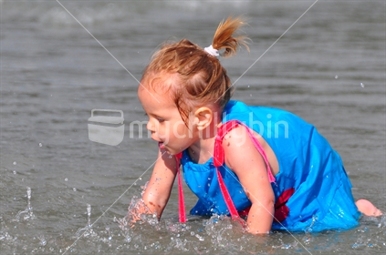 Chasing splashes; girl crawling in water.