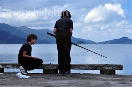 Boys fishing of wharf in Marlborough sounds