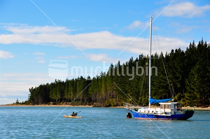 Mapua Estuary with a kayaker and yacht. 