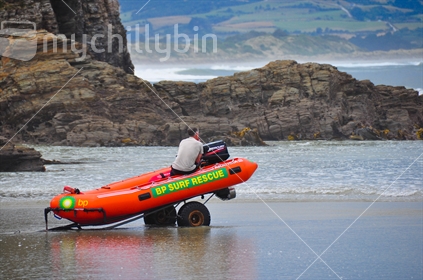 Life saver sitting in boat as it sinks into the sand; Brighton Beach, Otago